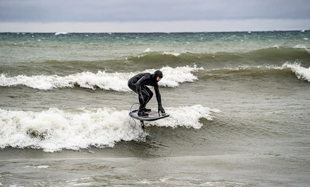 Man surfing in a wetsuit.